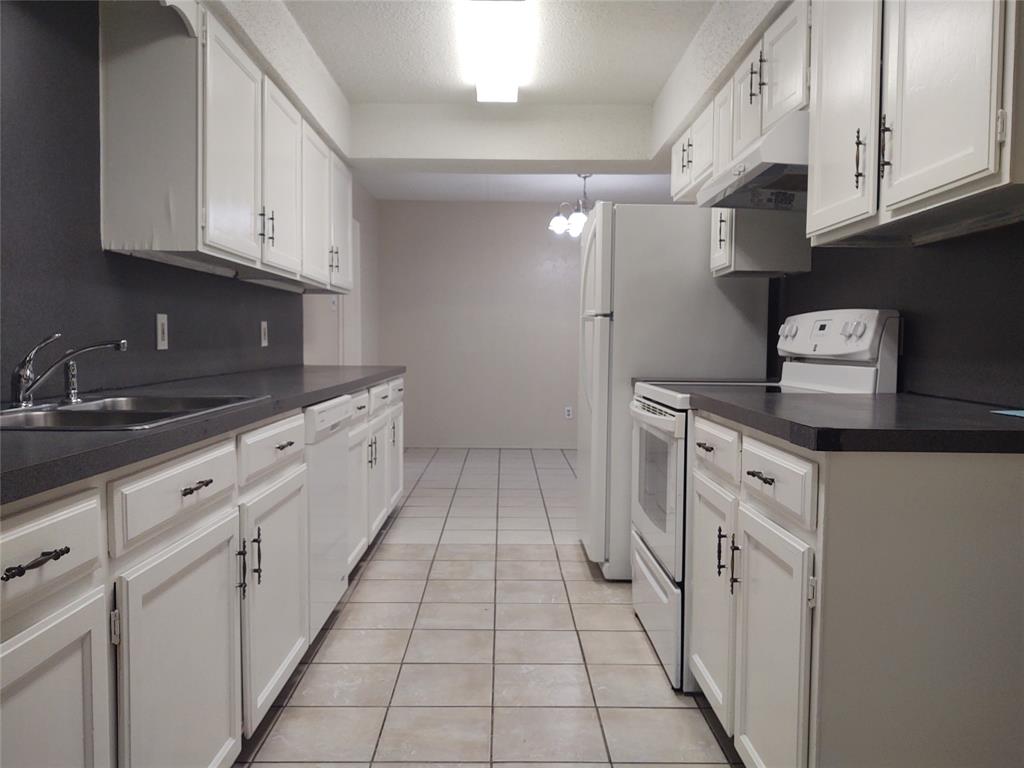 a kitchen with white cabinets and white appliances