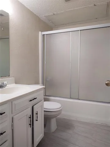 a bathroom with a sink a toilet a mirror and shower