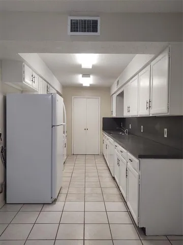 a large kitchen with a stove a refrigerator and a sink