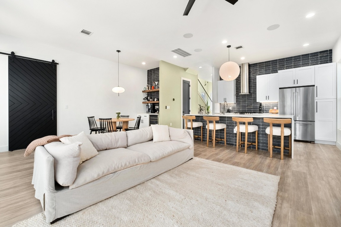 3302 Thompson Street, Unit 1 Austin, TX 78702 - Photo 5 of 32 a living room with furniture a wooden floor and a kitchen view