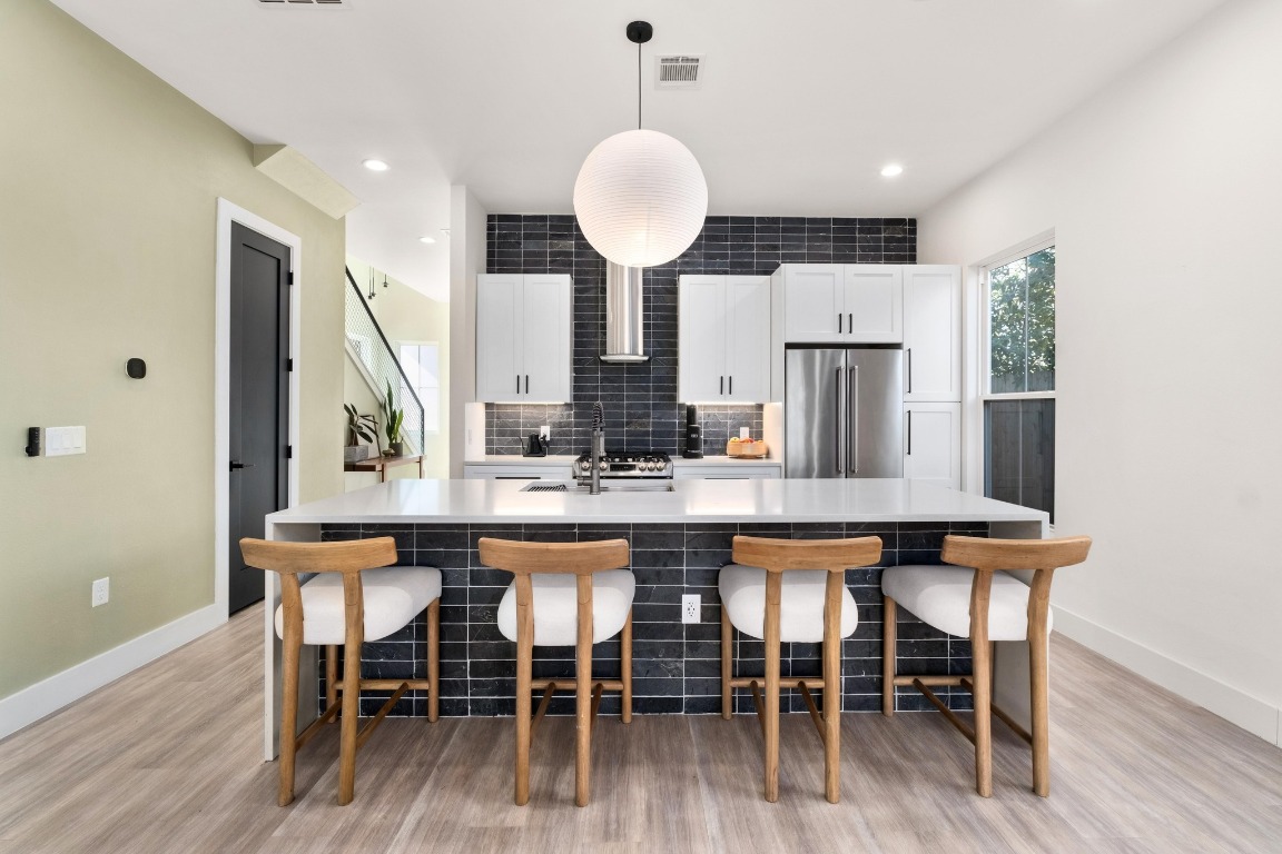 3302 Thompson Street, Unit 1 Austin, TX 78702 - Photo 8 of 32 a kitchen with stainless steel appliances granite countertop a dining table chairs and wooden floor
