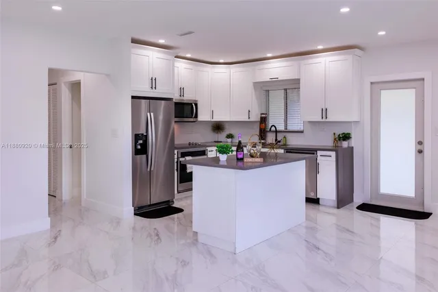a view of a kitchen with refrigerator and a window