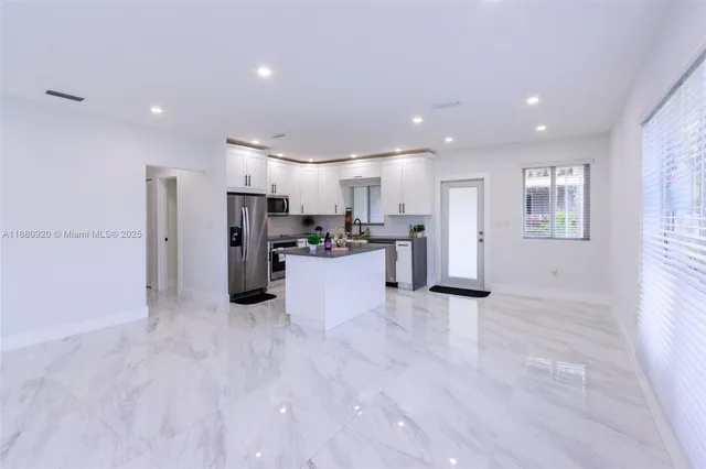 a kitchen with stainless steel appliances kitchen island granite countertop a stove a sink and a microwave