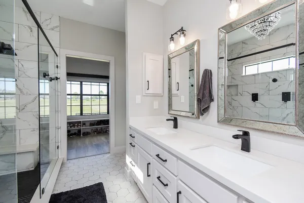 a bathroom with a double vanity sink a mirror a shower and a bathtub