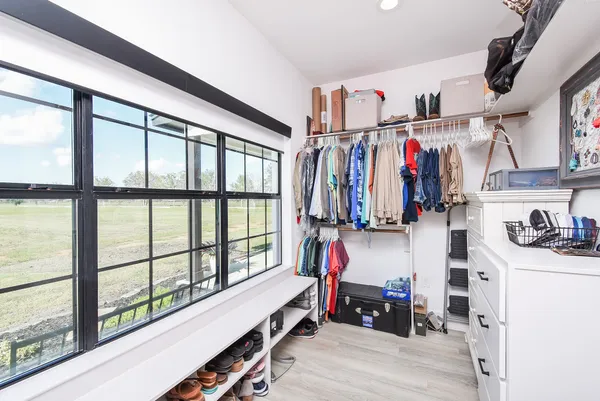a view of walk in closet with clothes and shoes