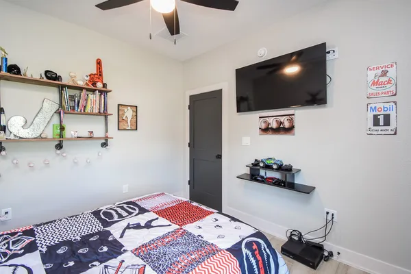 a bedroom with a bed and a flat screen tv