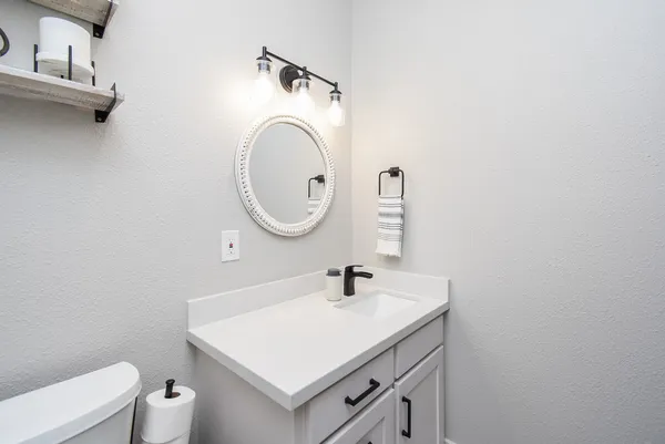 a bathroom with a toilet sink and mirror