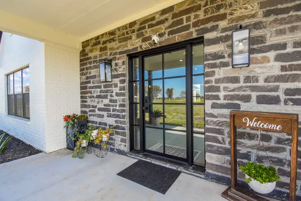 a view of a porch with a table and chairs and potted plants