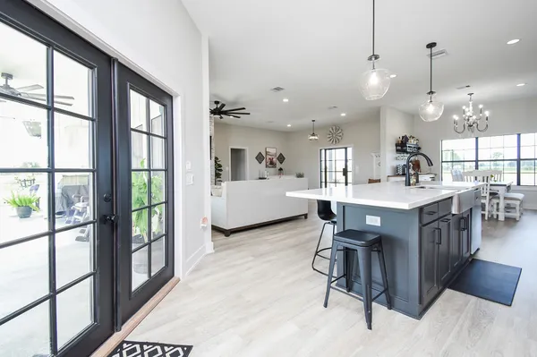 a view of a dining room and livingroom with furniture wooden floor a chandelier