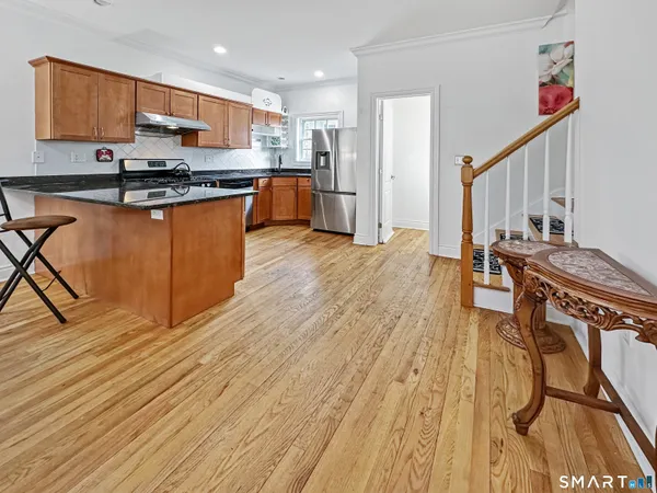 a kitchen with stainless steel appliances granite countertop a stove a sink and a refrigerator