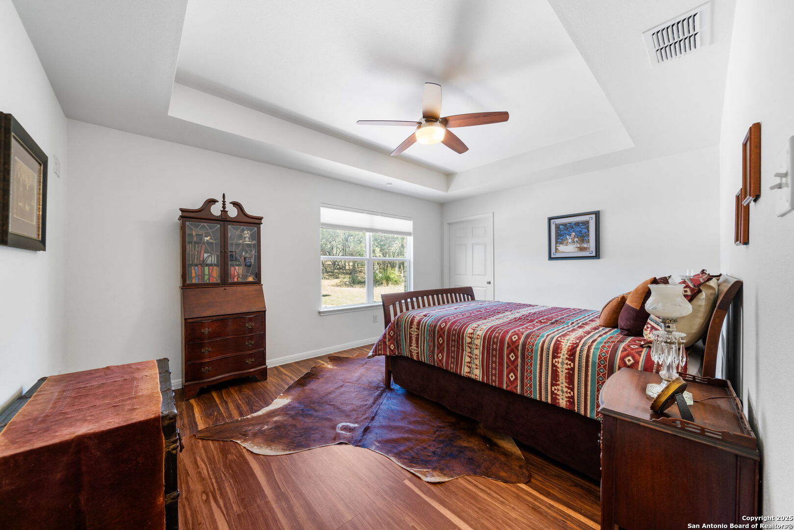 175 Forest Oaks Lane Lakehills, TX 78063 - Photo 21 of 36 a bedroom with a bed and wooden floor
