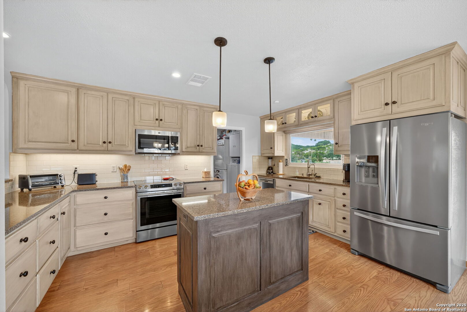 175 Forest Oaks Lane Lakehills, TX 78063 - Photo 9 of 36 a kitchen with stainless steel appliances granite countertop a refrigerator a sink dishwasher a stove and white cabinets with wooden floor