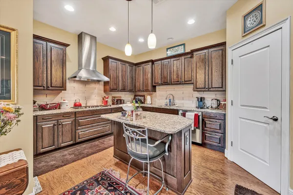 a kitchen with stainless steel appliances granite countertop a sink a stove a refrigerator and island