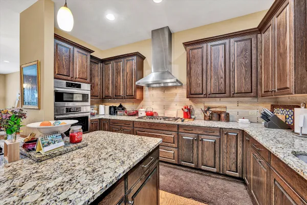 a kitchen with stainless steel appliances granite countertop a stove sink and cabinets