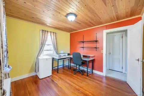 a view of a workspace with furniture and a window