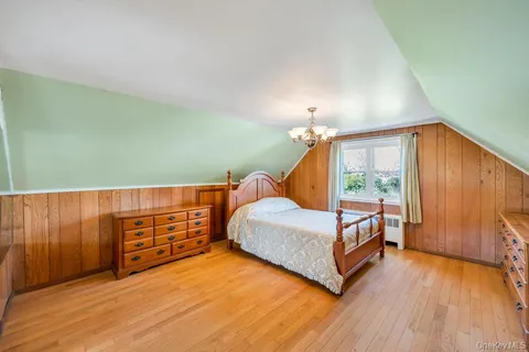 a view of a bedroom with furniture and wooden floor
