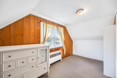 a view of an empty room with wooden floor and cabinet
