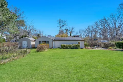 a view of a house with backyard and a garden