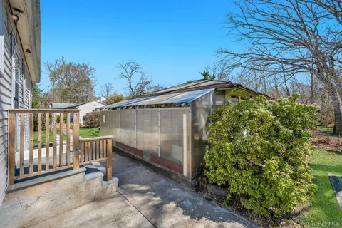 a view of a backyard with couches plants and large tree