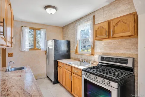 a kitchen with stainless steel appliances granite countertop a stove a sink and a refrigerator