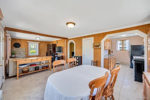 a bedroom with furniture a flat screen tv and a large window
