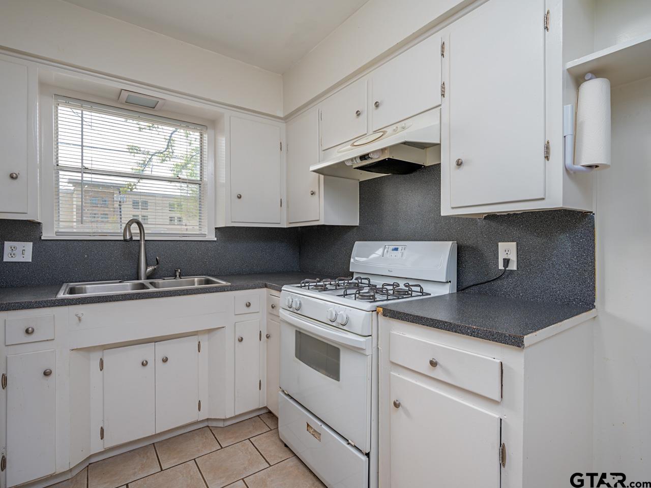 2722 McDonald Road Tyler, TX 75701 - Photo 11 of 28 a kitchen with cabinets appliances a sink and a window