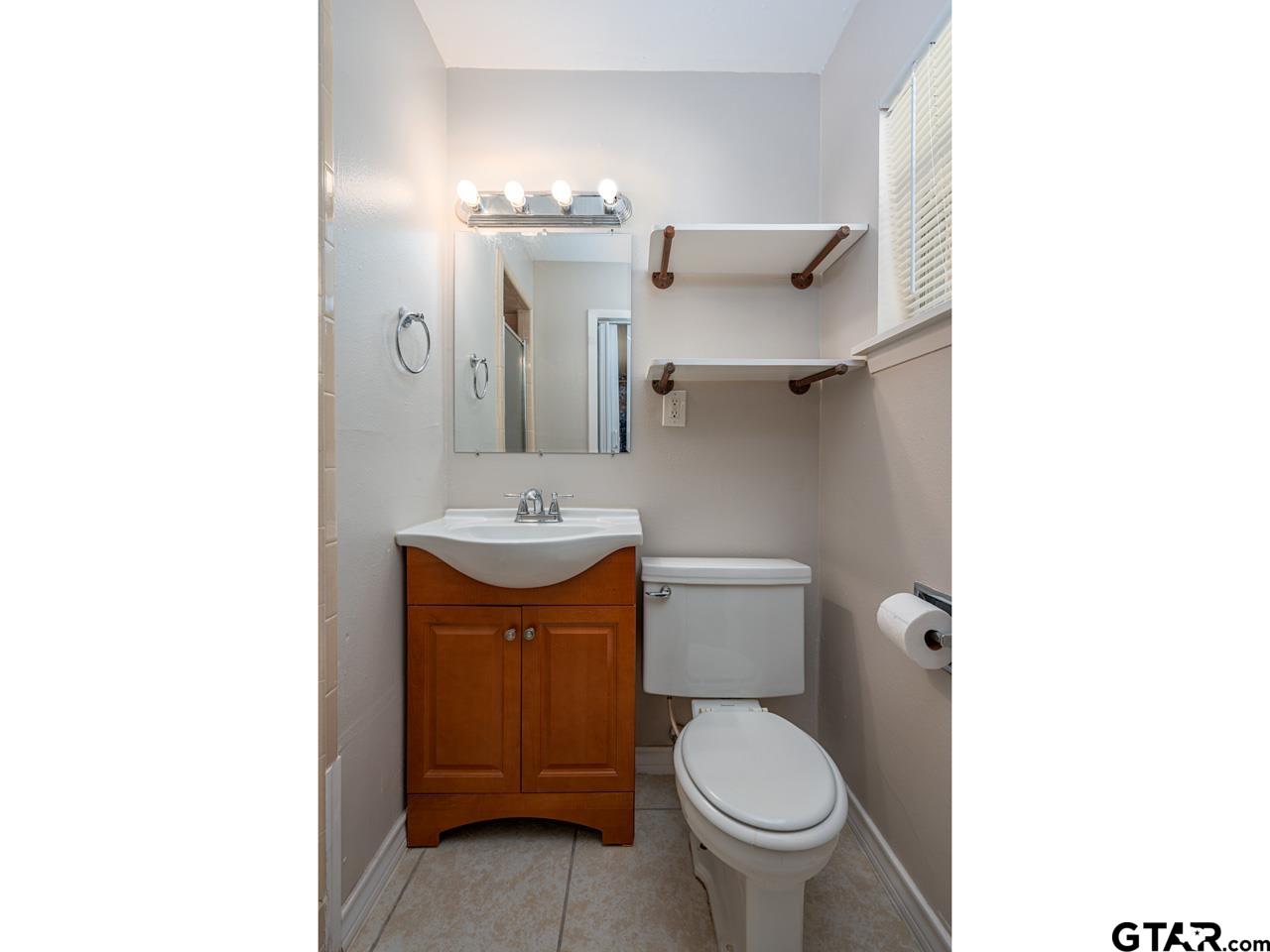 2722 McDonald Road Tyler, TX 75701 - Photo 17 of 28 a bathroom with a toilet sink and mirror