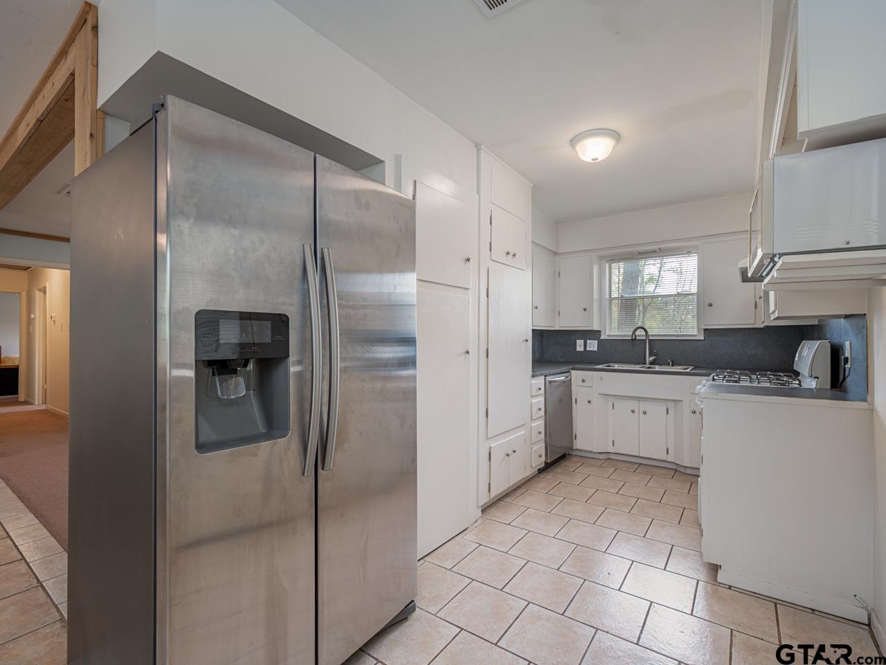 2722 McDonald Road Tyler, TX 75701 - Photo 10 of 28 a kitchen with a refrigerator a sink and cabinets
