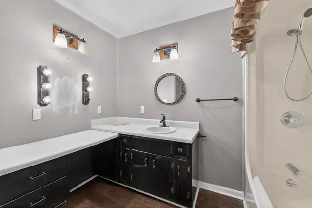 a bathroom with a sink a light fixture and a mirror