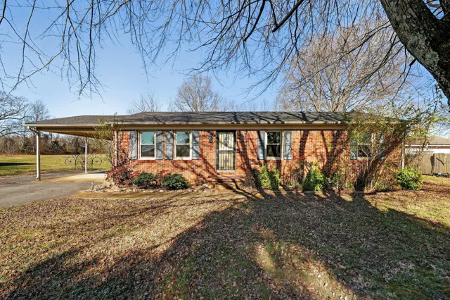 a view of a yard with wooden fence