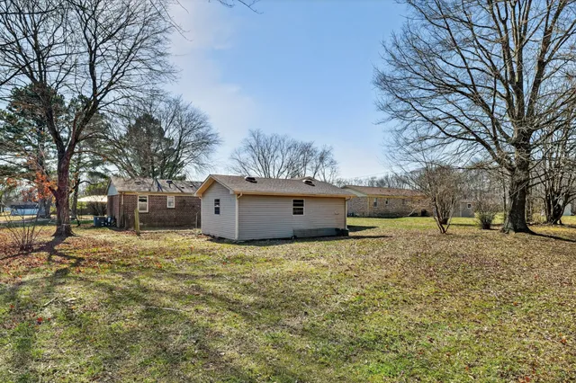 a yard with a house in the background