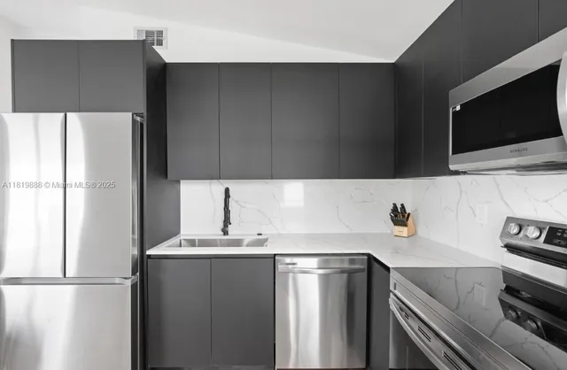 a kitchen with a sink and a stove top oven