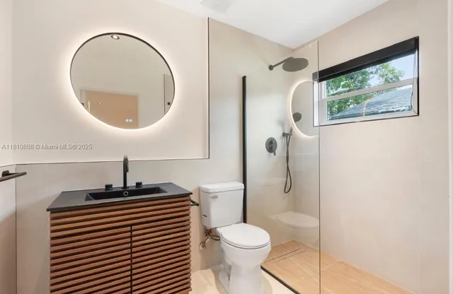 a bathroom with a toilet a sink and mirror