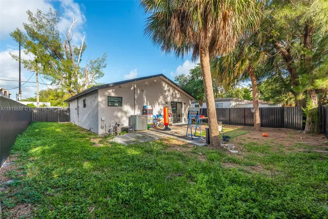 a view of a house with backyard and a tree