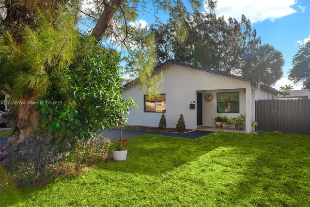 a front view of a house with a yard and trees