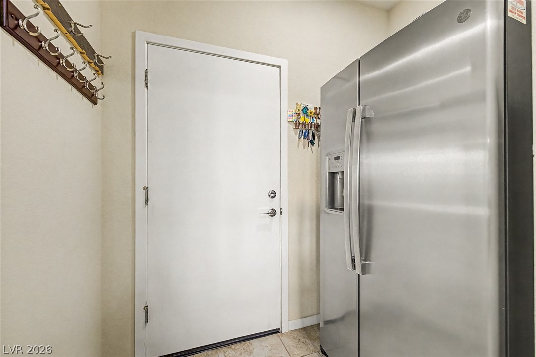 4914 East Beacon Ridge Drive Pahrump, NV 89061 - Photo 15 of 34 A well-equipped utility space featuring a modern refrigerator and convenient coat rack.