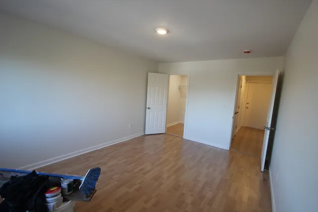an empty room with wooden floor and closet