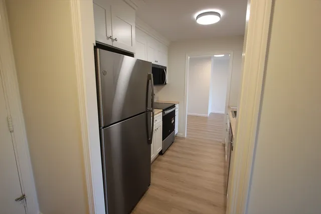 a view of a refrigerator in kitchen and wooden floor