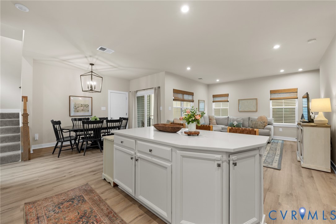 6504 Kinns Road Richmond, VA 23225 - Photo 15 of 34 Kitchen island featuring white cabinetry and a lig