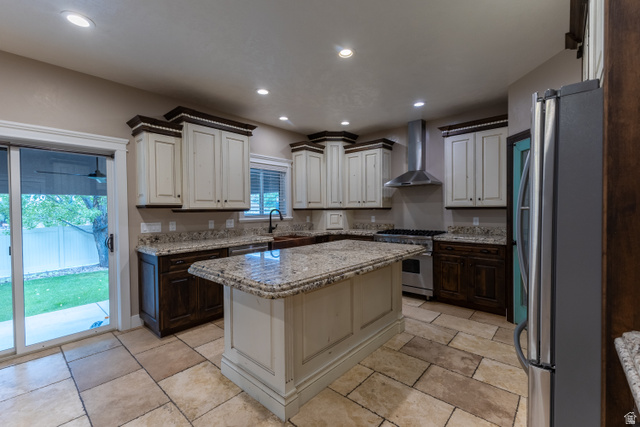 3565 West 1350th Street North Vernal, UT 84078 - Photo 11 of 54 Spacious kitchen featuring an island with a stone countertop, an integrated range hood, white and dark wood-finish cabinetry, and stone tile flooring