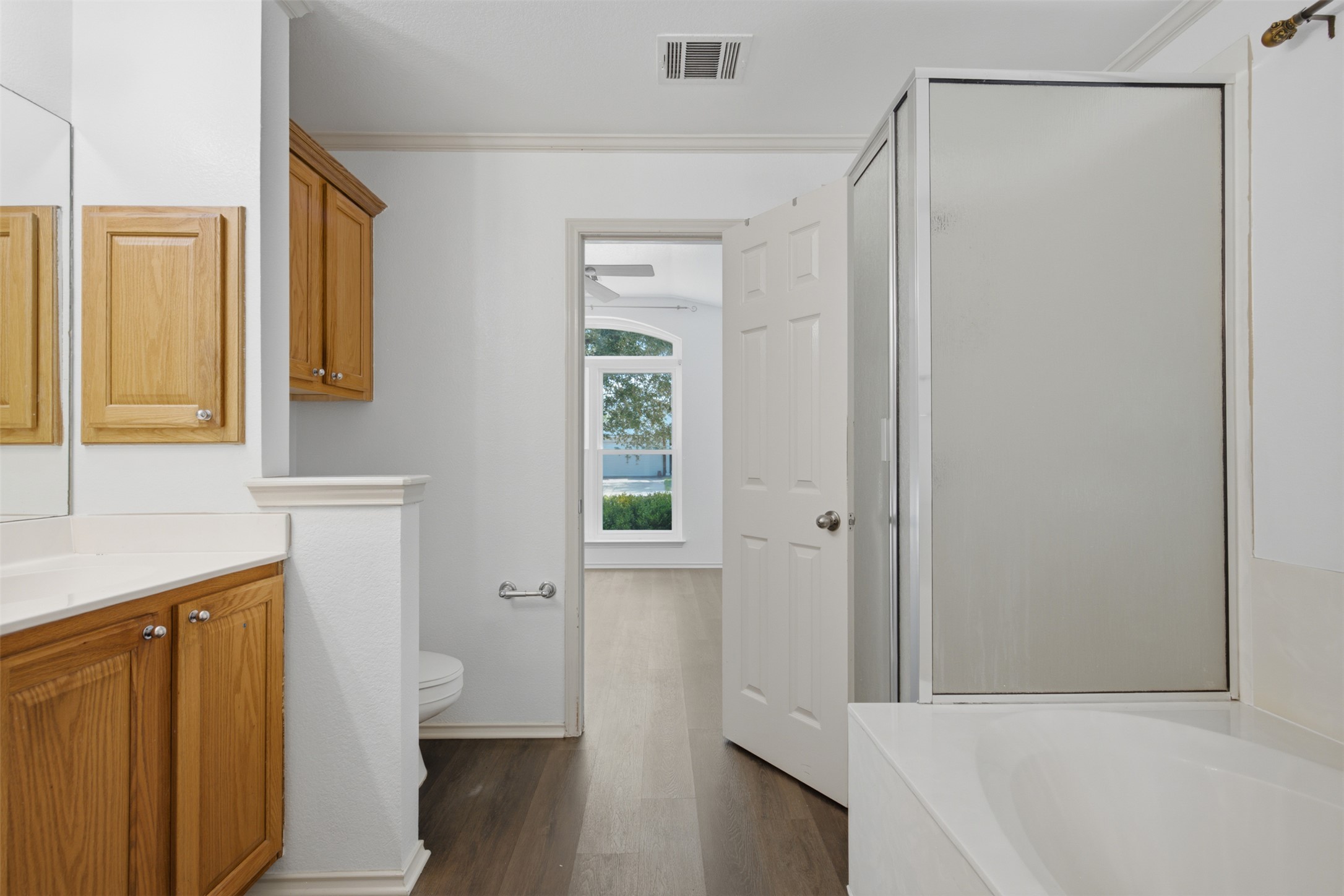 1416 Roxanne's Run Pflugerville, TX 78660 - Photo 18 of 35 A well-appointed bathroom offers a separate shower, a soaking tub, and ample vanity space with wood cabinetry.