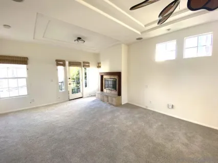 an empty room with windows and fireplace