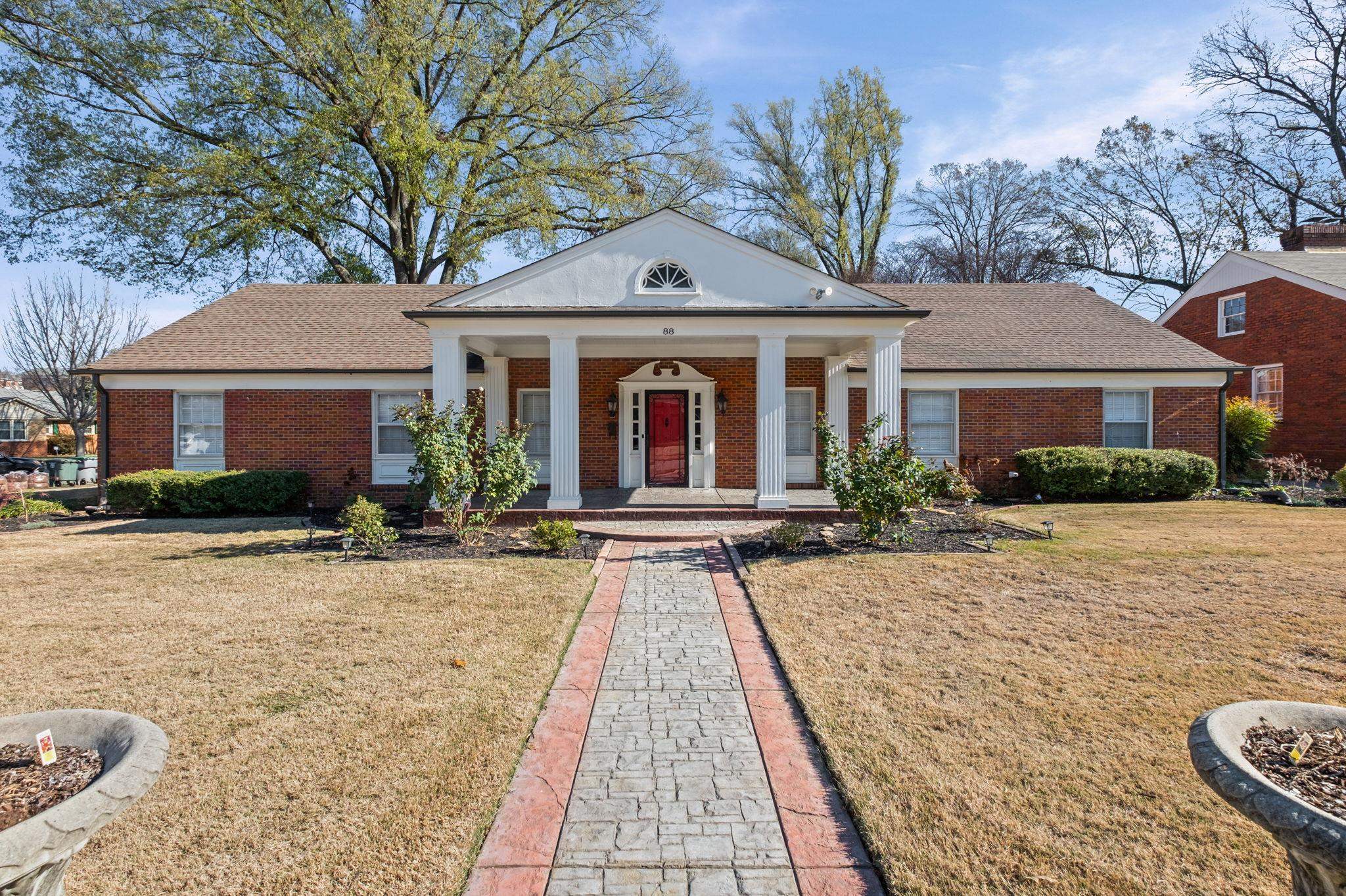 88 North Reese Street Memphis, TN 38111 - Photo 1 of 40 Neoclassical home featuring covered porch, brick siding, a front lawn, and a shingled roof