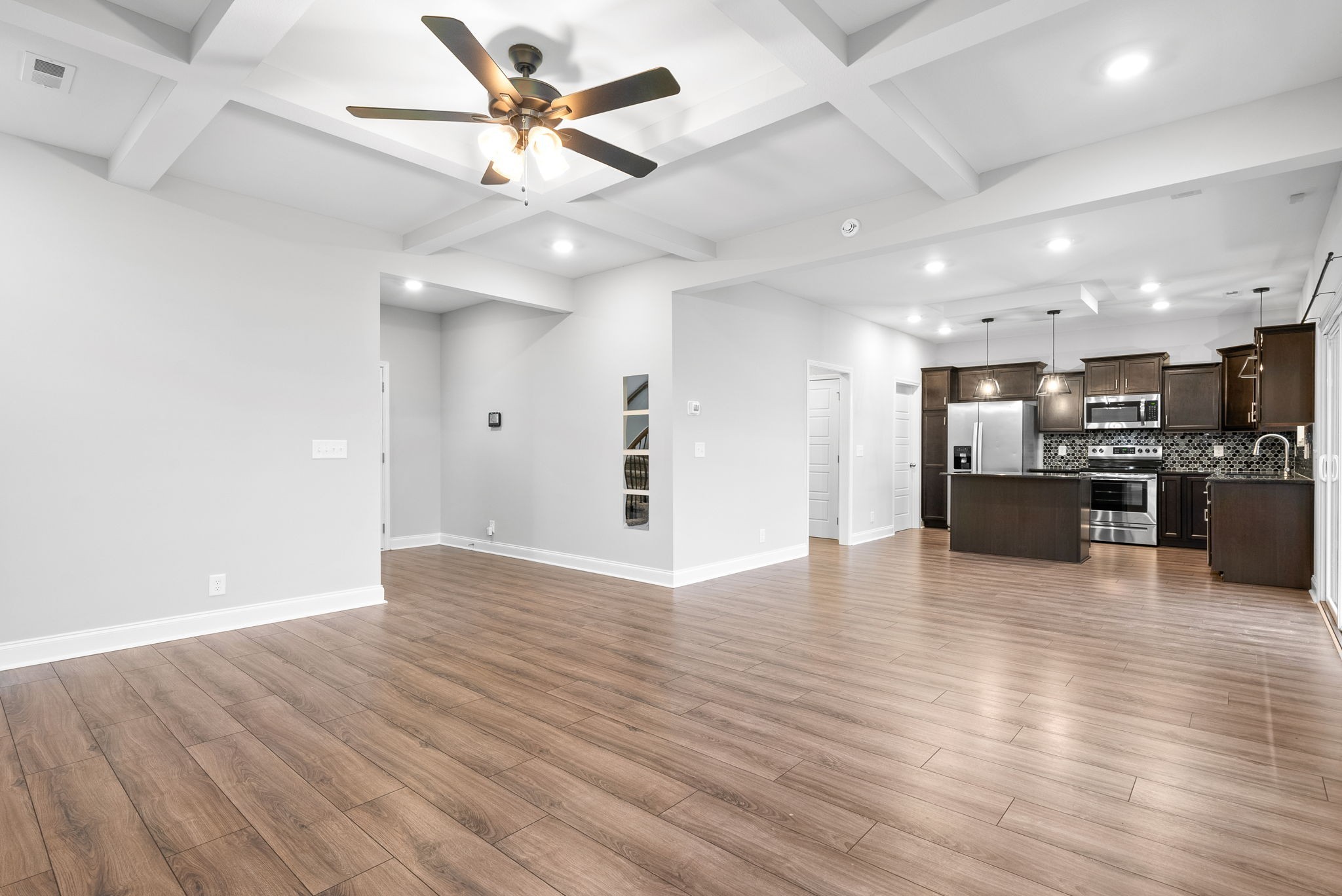 202 Copeland Road Clarksville, TN 37042 - Photo 6 of 19 an empty room with wooden floor and a kitchen