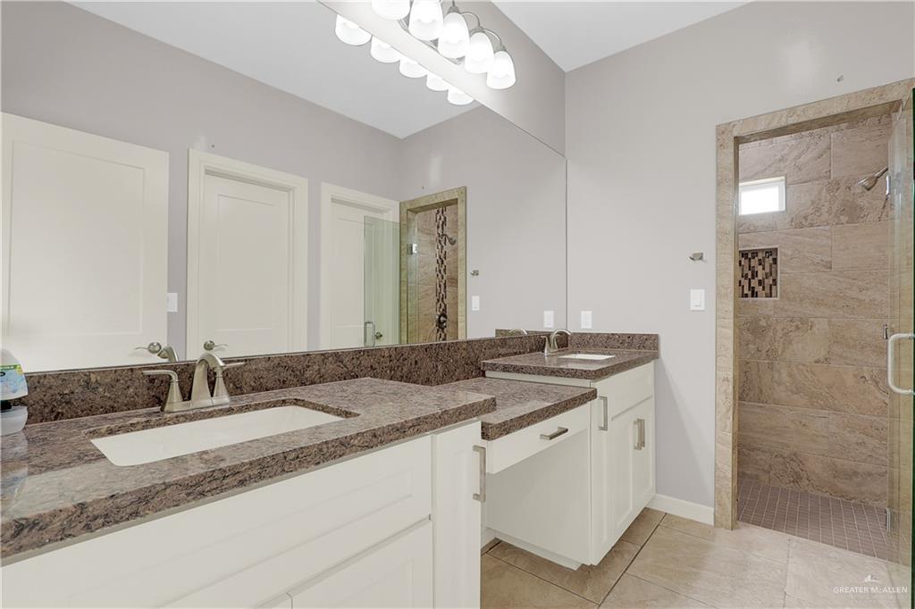 824 Lark Street Alamo, TX 78516 - Photo 11 of 17 Full bath featuring a shower stall, two vanities, and light tile patterned flooring