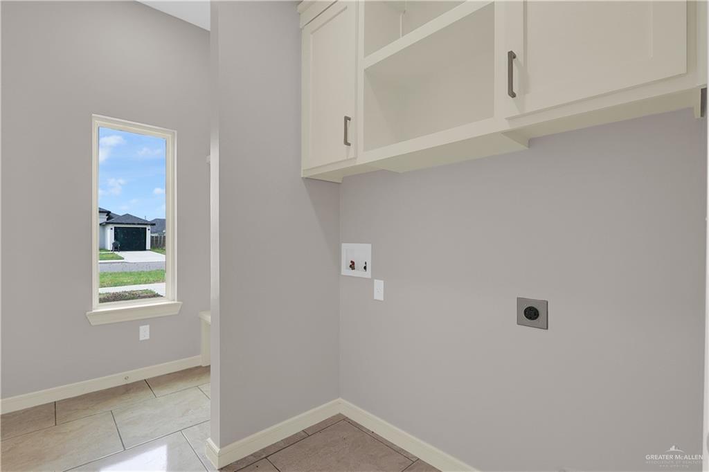 824 Lark Street Alamo, TX 78516 - Photo 15 of 17 Washroom with light tile patterned floors, hookup for a washing machine, hookup for an electric dryer, and cabinet space