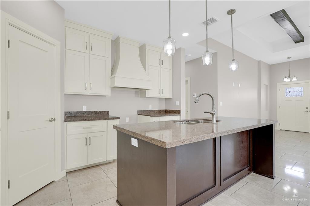 824 Lark Street Alamo, TX 78516 - Photo 6 of 17 Kitchen with dark stone countertops, custom range hood, hanging light fixtures, and recessed lighting