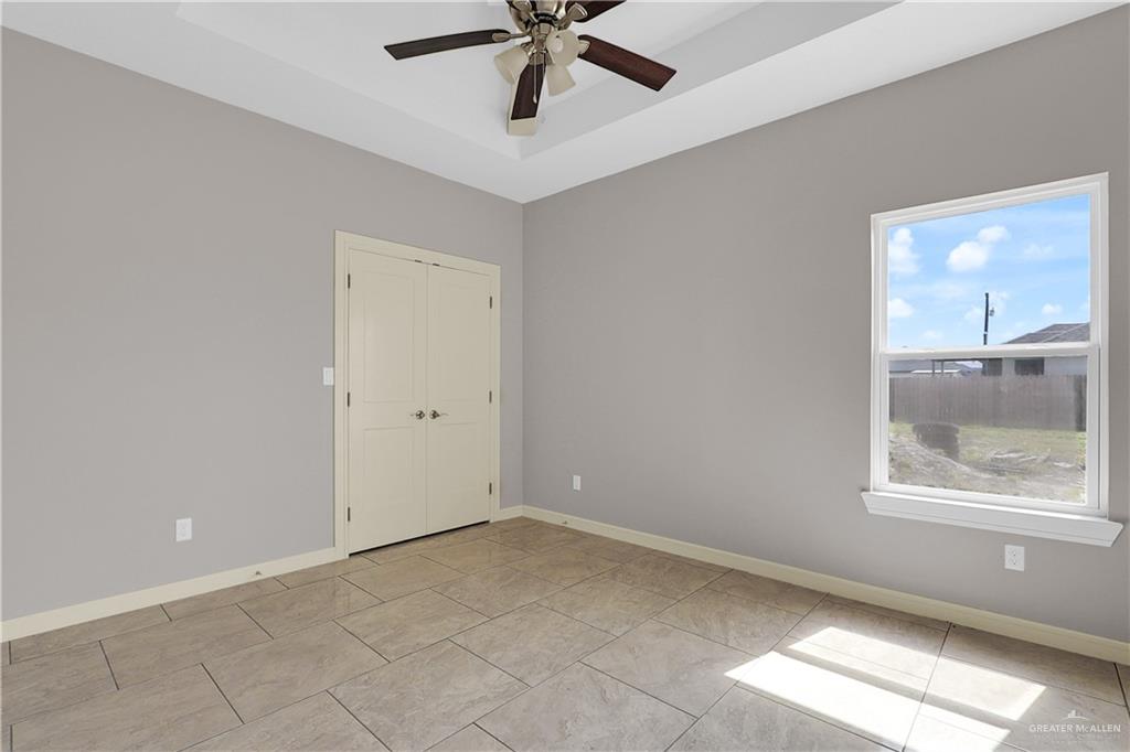 824 Lark Street Alamo, TX 78516 - Photo 10 of 17 Spare room featuring a raised ceiling, light tile patterned floors, and ceiling fan