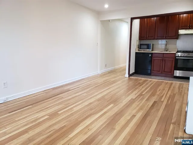 a view of kitchen with wooden floor and cabinets