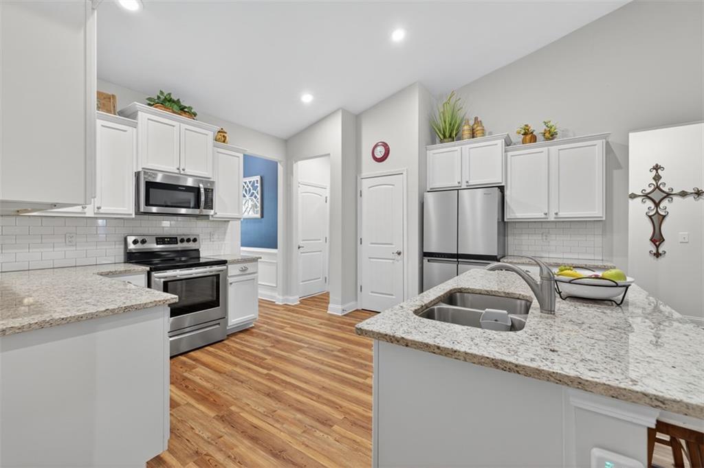 829 River Fall Drive Jefferson, GA 30549 - Photo 13 of 63 a kitchen with granite countertop a sink stove and refrigerator